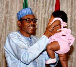 President Muhammadu Buhari beams with smiles as he plays with grand-daughter after immunising her . . . late July in Abuja. Photo: State House.