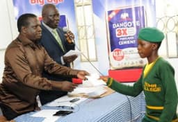 DGM, Human Resources & Admin, Dangote Cement Ibese Plant, McDappa Ngo (L); DGM, External Relations, Joseph B. Alabi presenting scholarship award to Miss Usman Yetunde Iyabode of Yewa Egbado College, Ilaro, Ogun State at Dangote Cement PLC presentation of scholarship award to Ibese indigenes in June 2014.