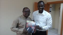 Isaac Umunna and Kudo Eresia-Eke, Ph.D display a copy of NLNG Magazine. 