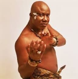 Photo shows Mike Okri barechest.