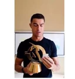 Cristiano Ronaldo reacts after receiving the 'Best of All Time' award ahead of Lionel Messi