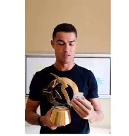 Cristiano Ronaldo reacts after receiving the 'Best of All Time' award ahead of Lionel Messi