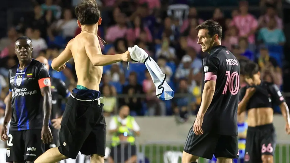 Pitch invader wrestles Messi to the ground during football match